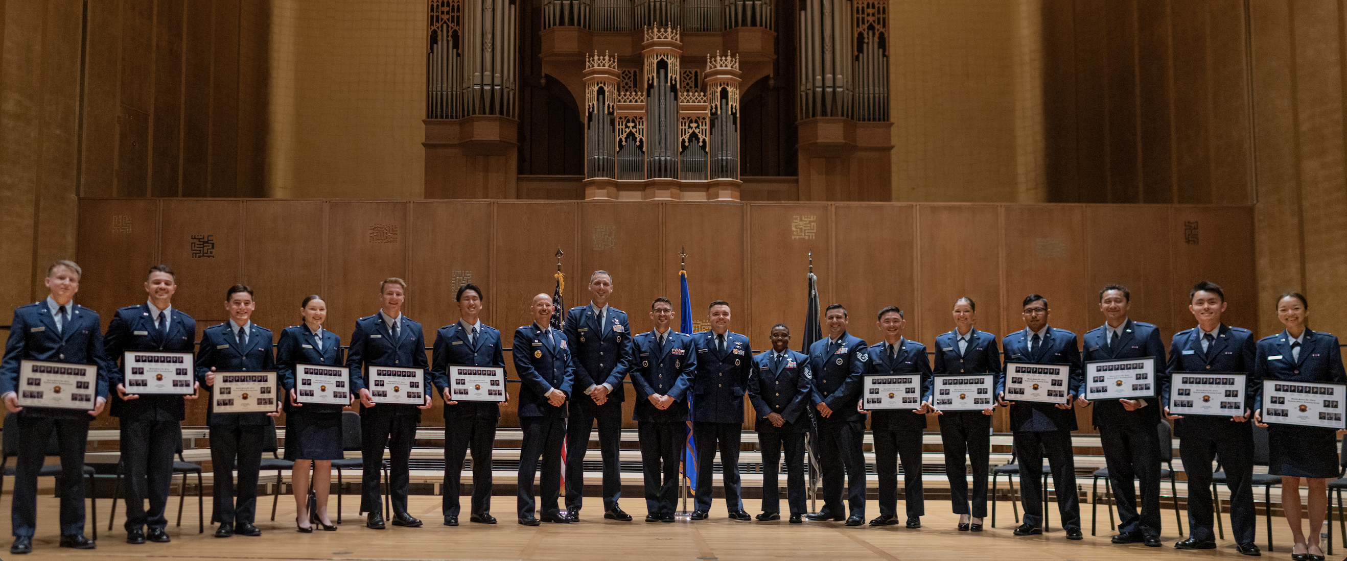 Group shot of cadets holding awards at a large venue
